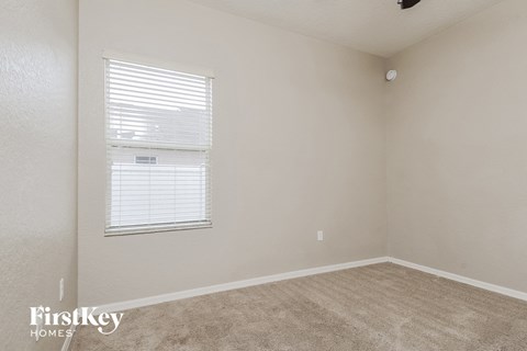a bedroom with a window and a carpeted floor