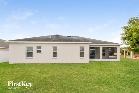 a white house with a grassy yard and a gray roof