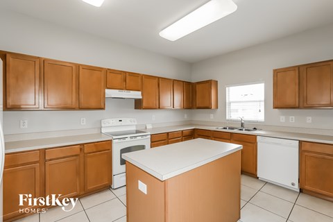 A kitchen with wooden cabinets and a white island.