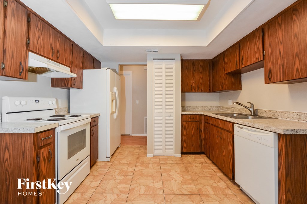 a kitchen with white appliances and wooden cabinets