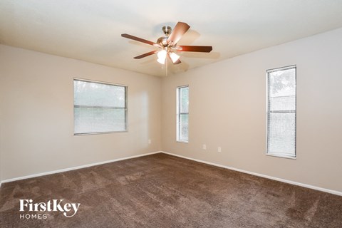 a living room with carpet and a ceiling fan
