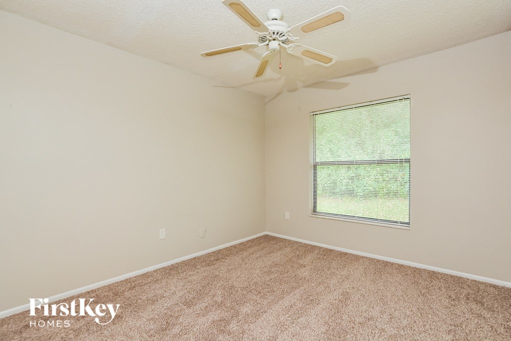 a bedroom with carpet and a ceiling fan