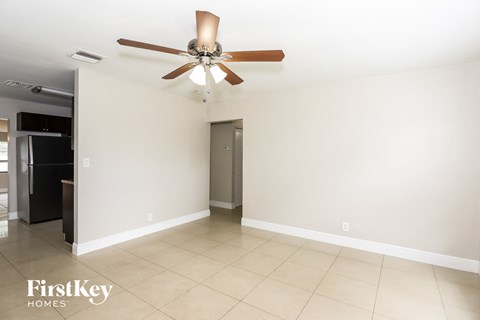 A room with a ceiling fan and a door.