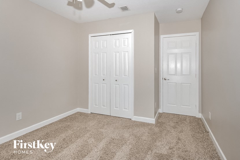 a bedroom with two white doors and a carpeted floor