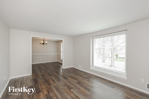 a living room with a large window and wooden floors