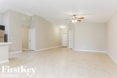 A spacious room with a ceiling fan and tiled flooring.