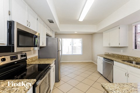 A kitchen with granite countertops and white cabinets.