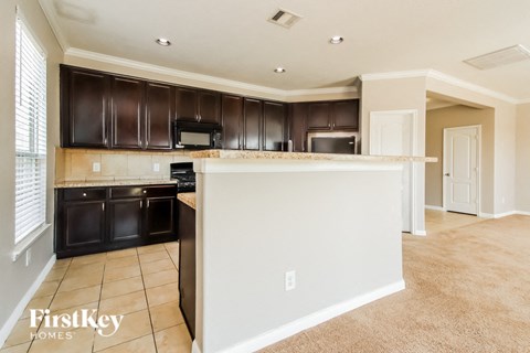 A kitchen with dark brown cabinets and a white island.