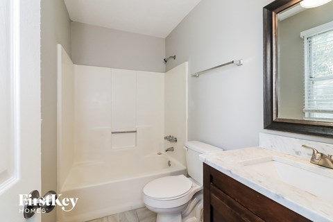 A white bathroom with a toilet, sink, and tub.