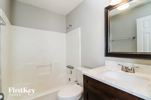 A white toilet sits next to a sink in a bathroom.