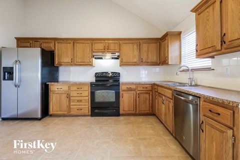 A kitchen with wooden cabinets and a stainless steel refrigerator.