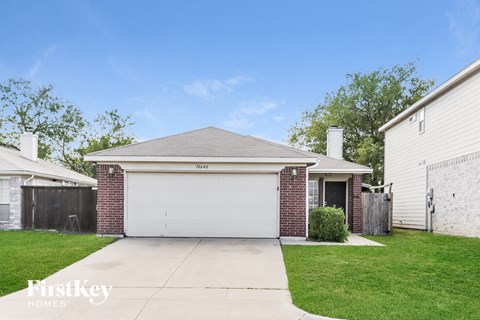 a brick house with a white garage door and a lawn