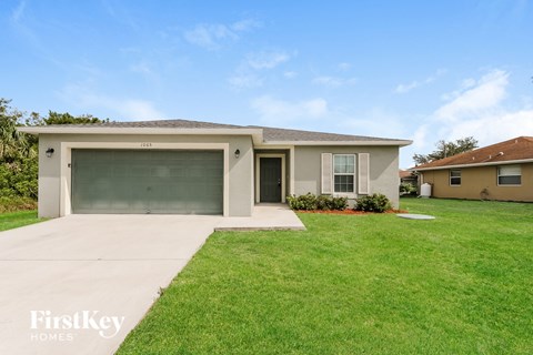 a beige house with a driveway and a garage door