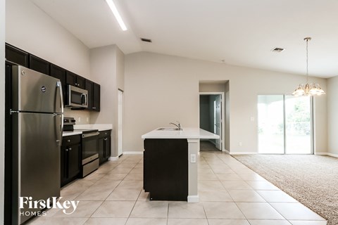 an empty kitchen with stainless steel appliances and a white counter top