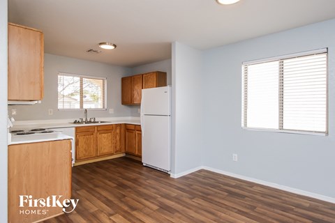 a kitchen with wood flooring and a white refrigerator