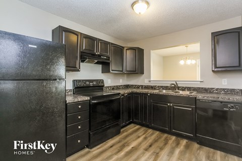 A kitchen with black appliances and cabinets.