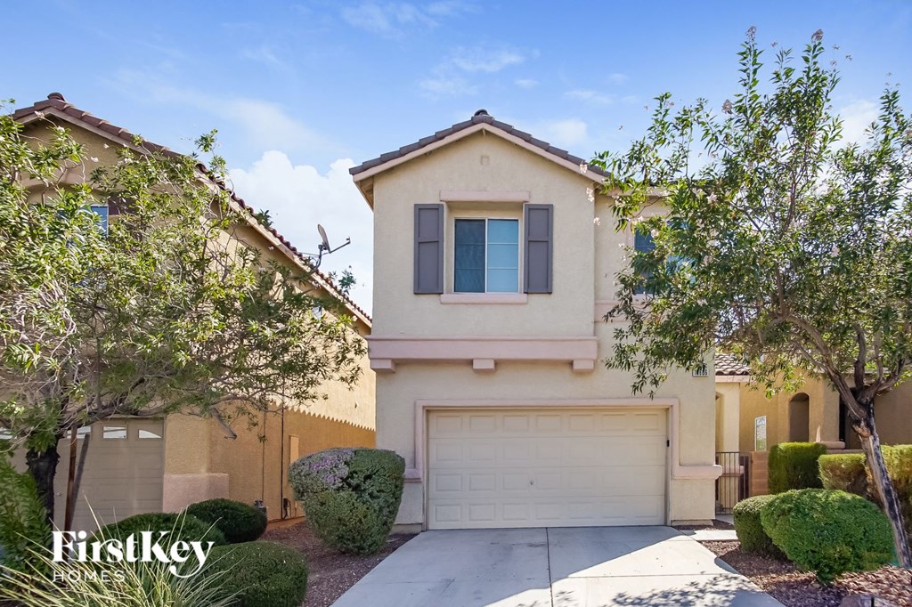 front view of a house with a garage door and trees