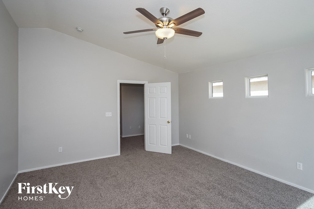 a bedroom with a ceiling fan and a door to a closet