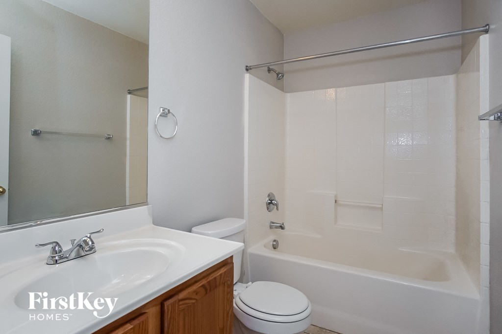 a bathroom with a sink toilet and tub and a mirror