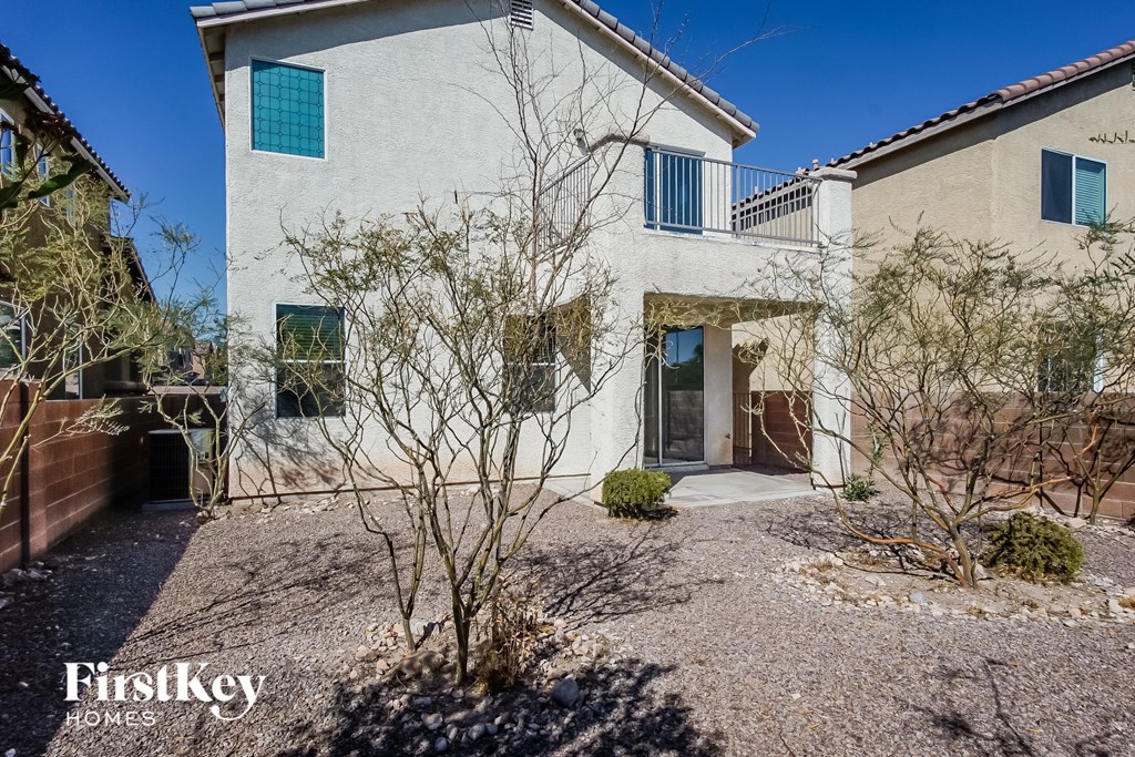 a white house with blue windows and a gravel driveway