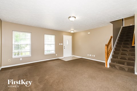 A spacious room with a staircase leading to the upper floor.