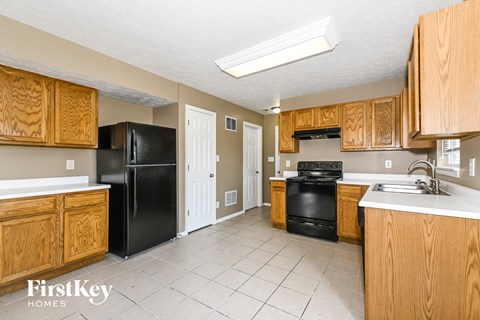 A kitchen with wooden cabinets and black appliances.