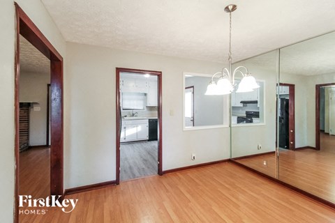 a living room with a mirror and a wooden floor