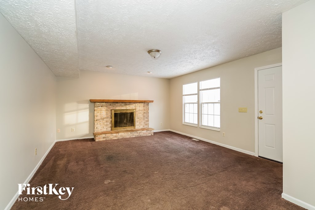 A room with a fireplace and a door on the right side.