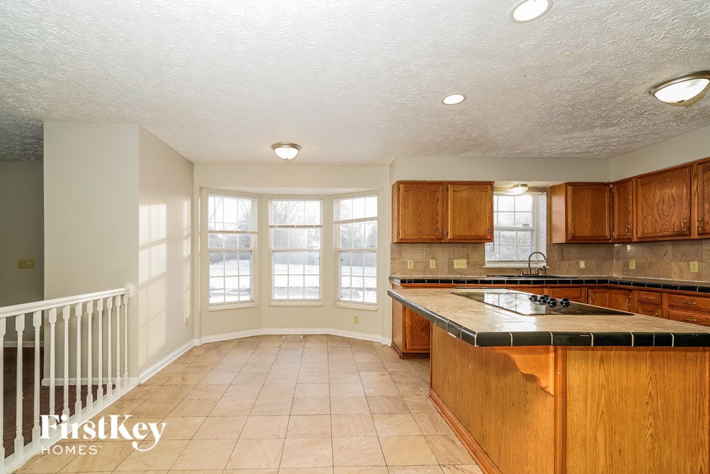 A kitchen with wooden cabinets and a marble countertop.