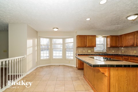 A kitchen with wooden cabinets and a marble countertop.