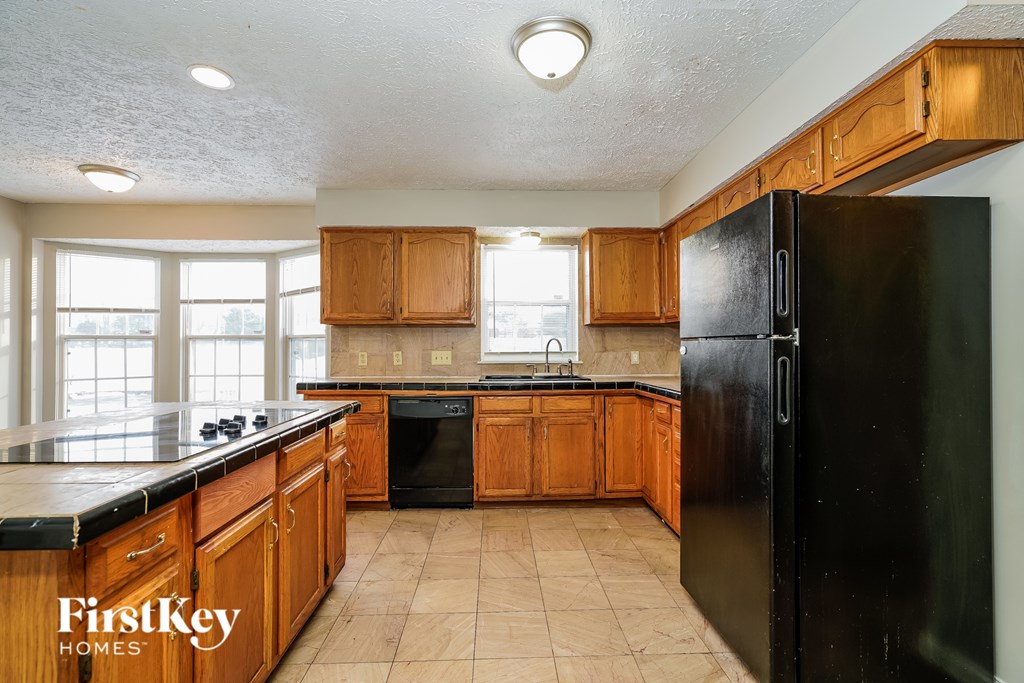 A kitchen with wooden cabinets and black appliances.