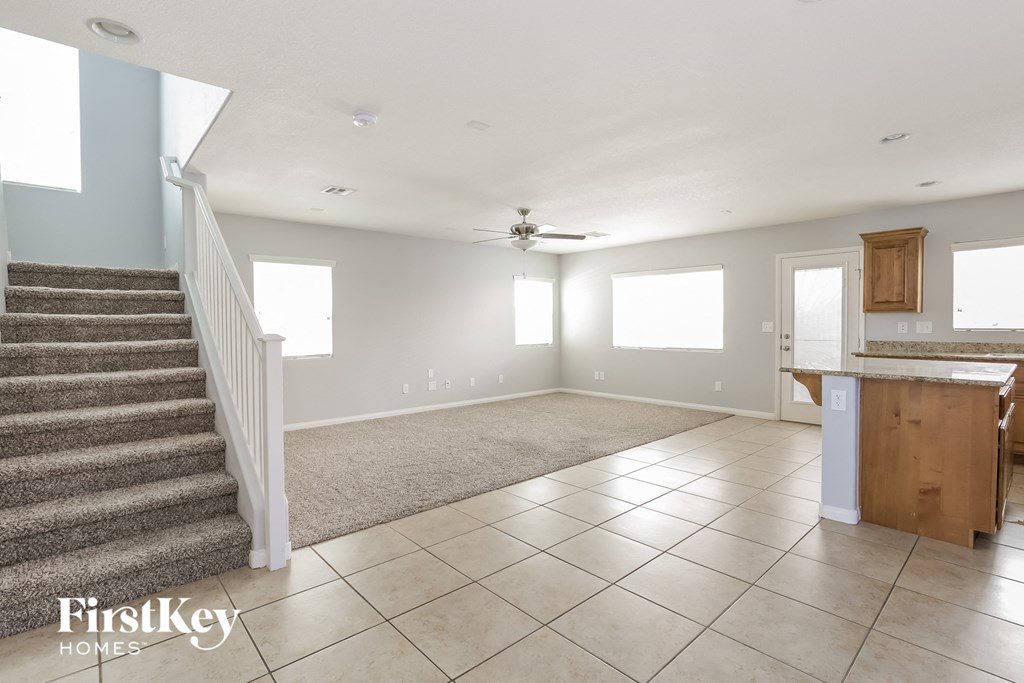 A spacious living room with a staircase leading to the upper floor.
