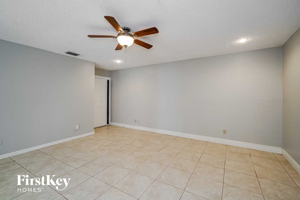 the living room has a tile floor and a ceiling fan