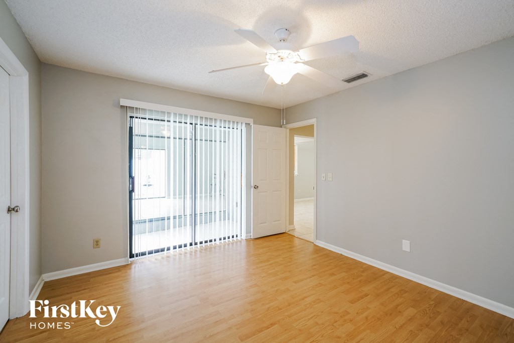 a living room with a wood floor and a ceiling fan