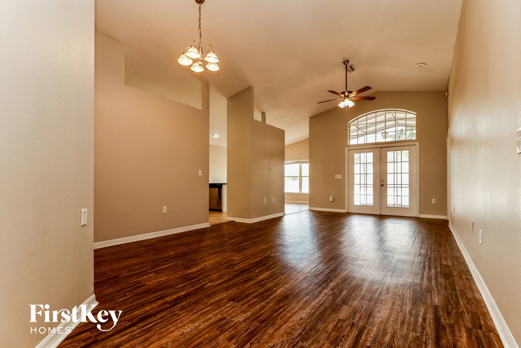 the living room and dining room of an empty house with wood floors