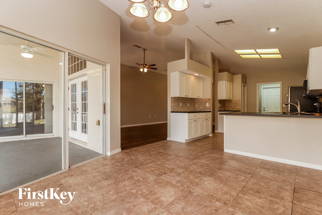 an empty kitchen and living room with a door to a patio