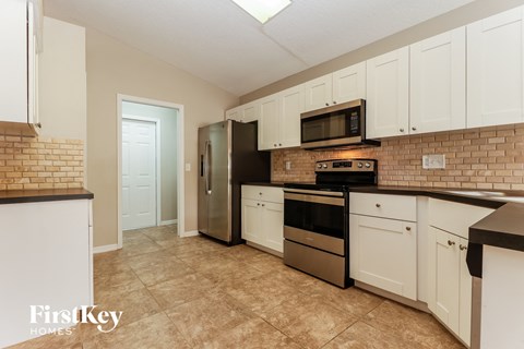 a kitchen with white cabinets and stainless steel appliances
