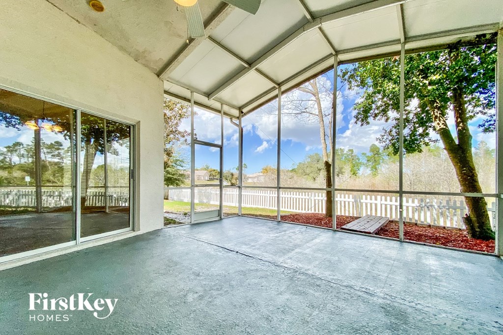 an empty living room with glass doors and a view of a yard and a deck
