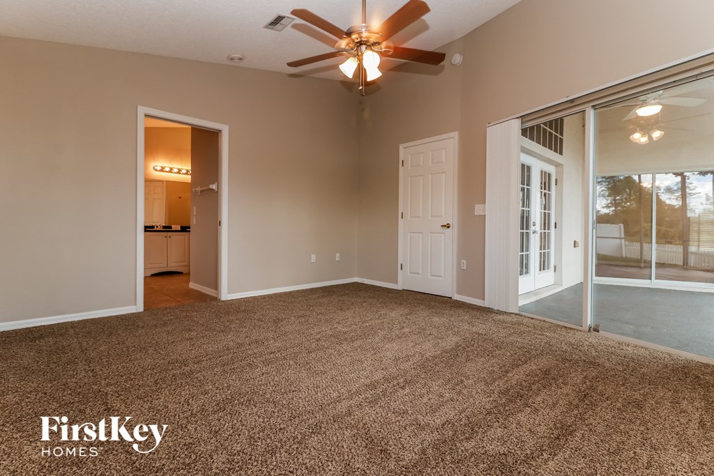 the living room of an empty house with a ceiling fan