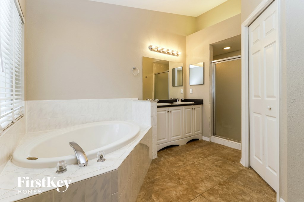 a bathroom with a large tub and a sink and a mirror