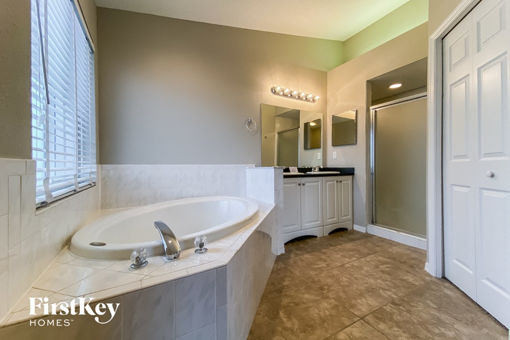 a bathroom with a large tub and a sink and a mirror