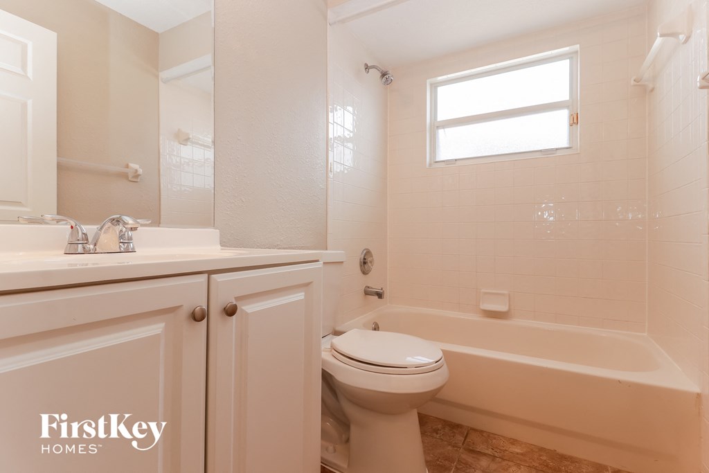 a bathroom with a toilet and a tub and a sink
