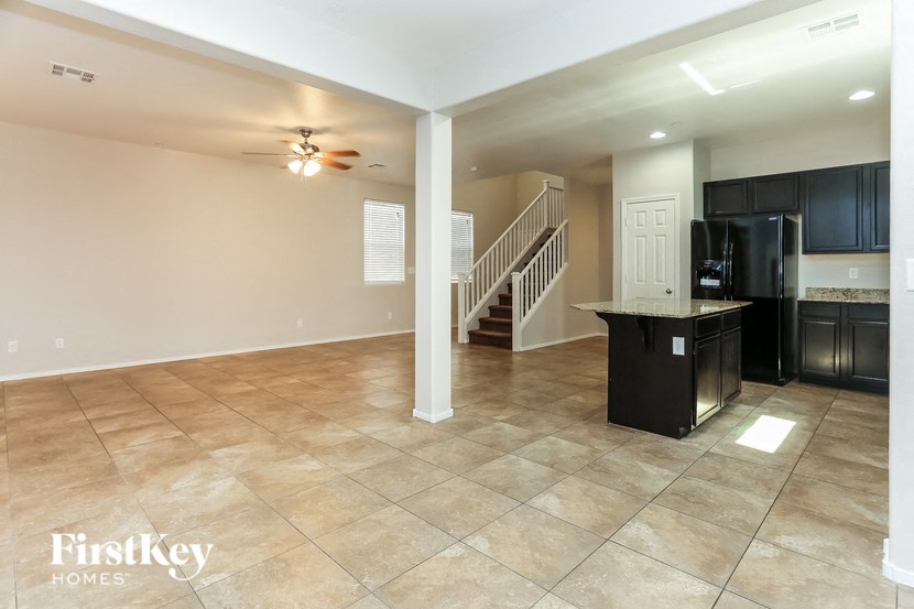 A spacious kitchen and living room with a staircase leading to the upper floor.