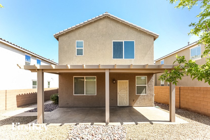 A house with a beige exterior and a gravel driveway.