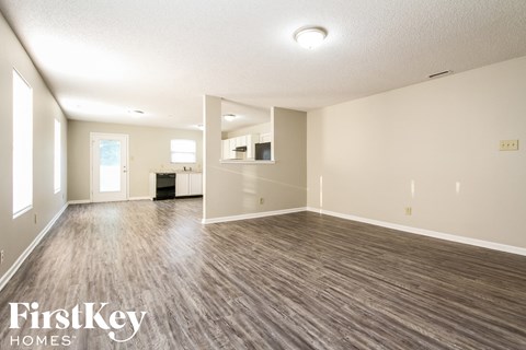 A spacious room with wooden flooring and a white ceiling.