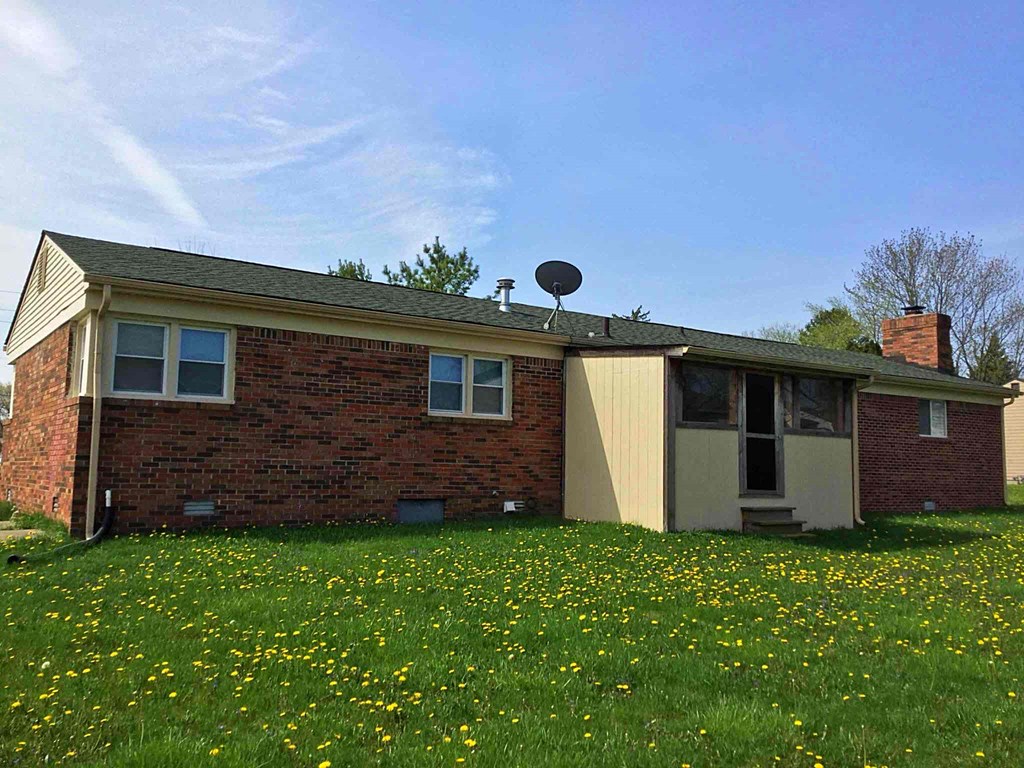 a small brick house with a satellite dish on the roof