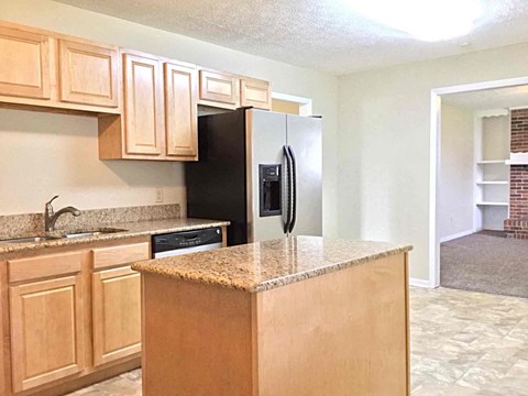 a kitchen with wooden cabinets and a black refrigerator