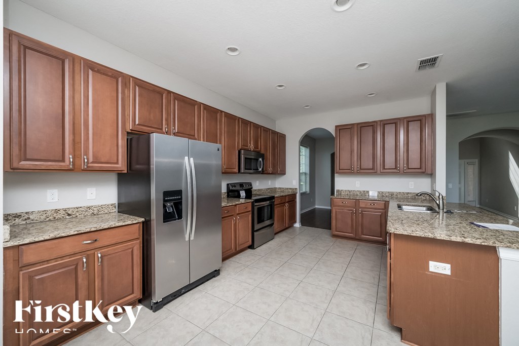 A kitchen with brown cabinets and a stainless steel refrigerator.