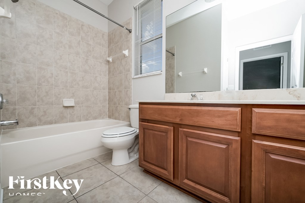A bathroom with a tub, toilet and sink.