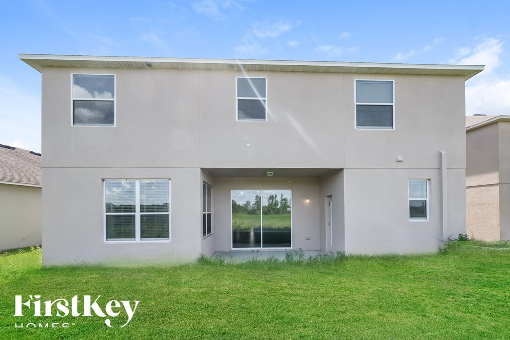 A beige house with a glass door and windows.